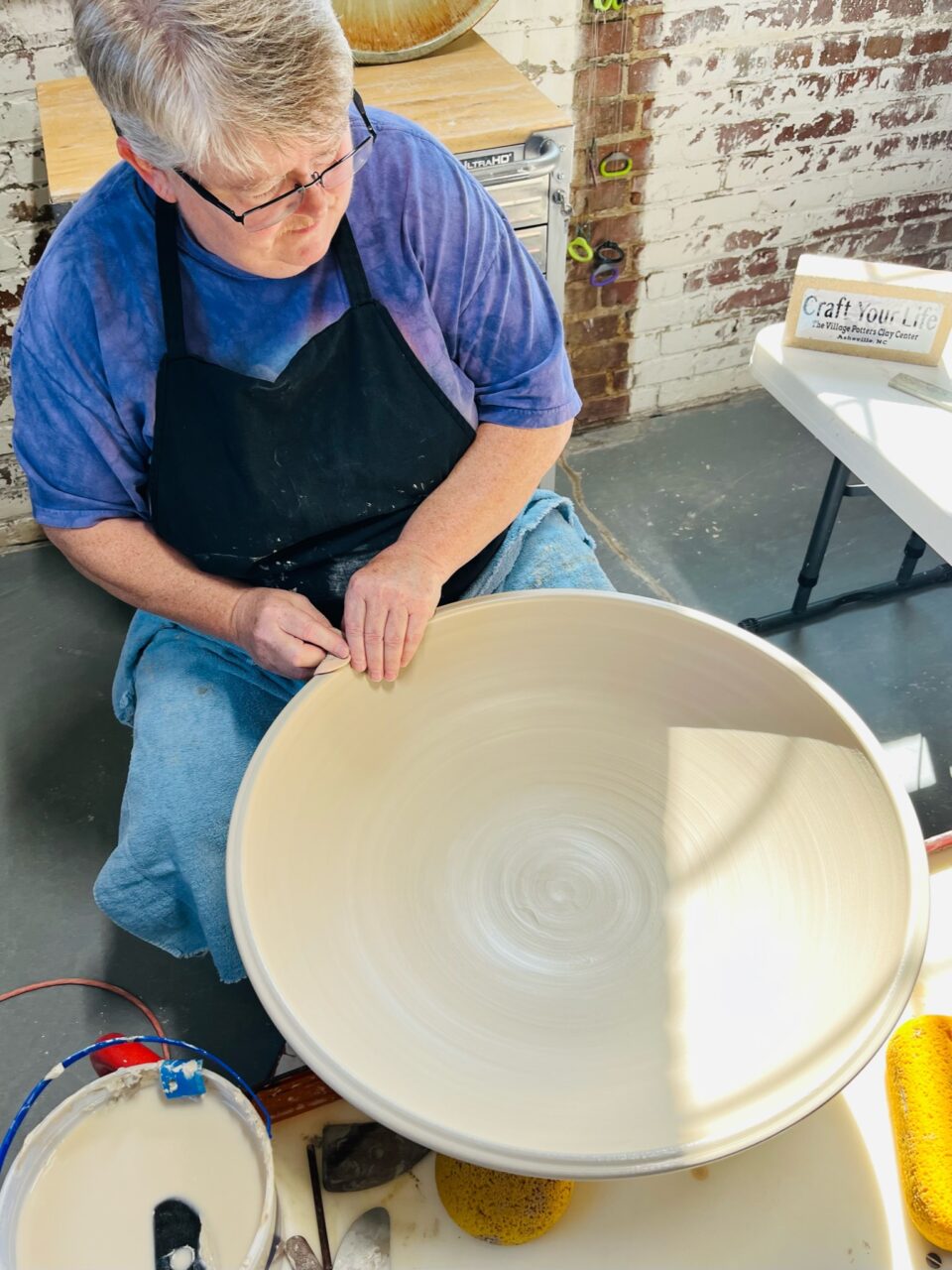 Julia Mann throwing large bowl on potters wheel, view from above
