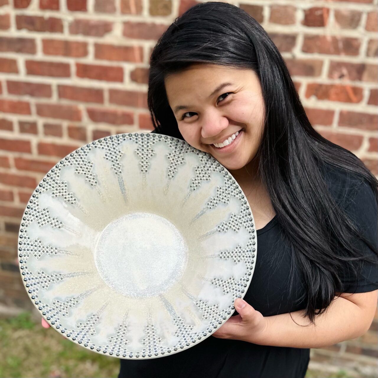 Katie Meili Messersmith holding finish pot, statement bowl, dot pots, infinite cobalt whispers, face close to pot