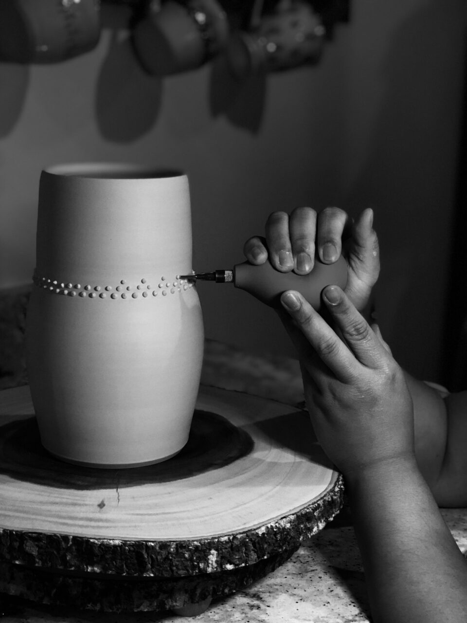 Katie Meili Messersmith close up of hands adding slip trailed dots to leather hard pot