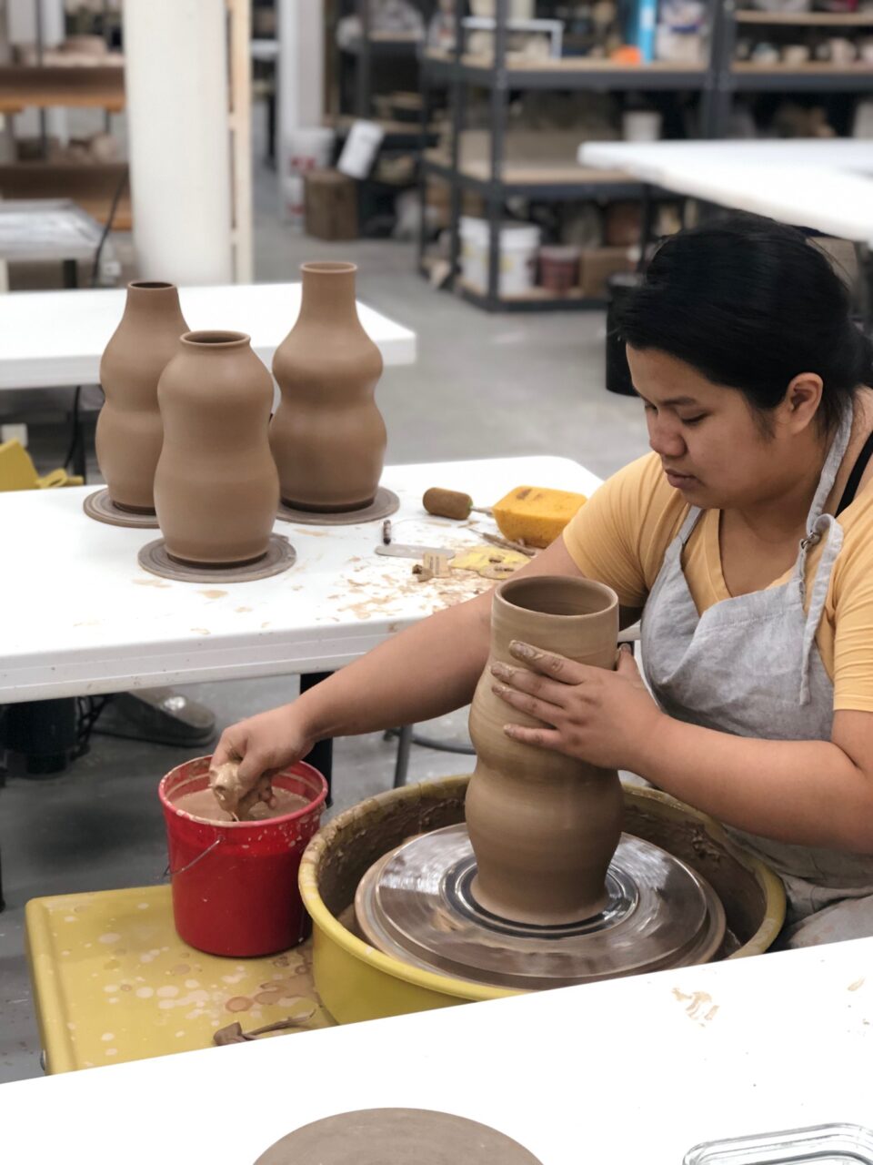 Katie Meili Messersmith fresh thrown vases, red clay, throwing at potters wheel, our stock image, silhouette view 6