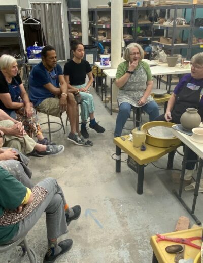 Julia Mann demonstrating moon vases at potters wheel, surrounded by students, teaching center, intermediate wheel class